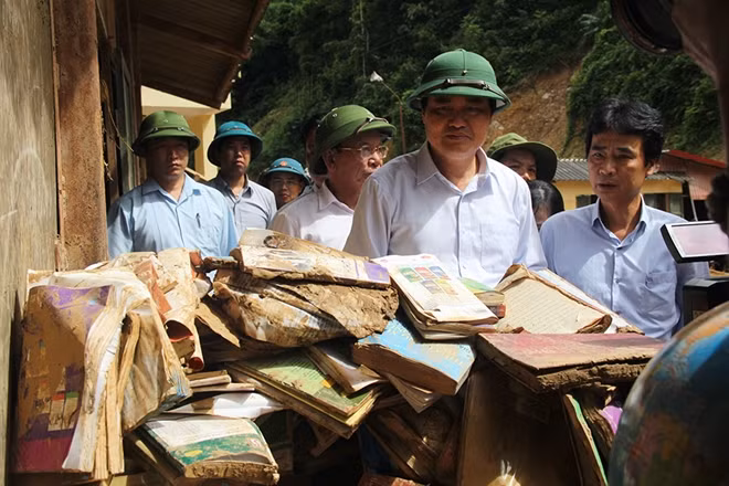 Bộ trưởng Phùng Xuân Nhạ buồn bã chứng kiến toàn bộ SGK và đồ dùng học tập của học sinh bị hư hại.