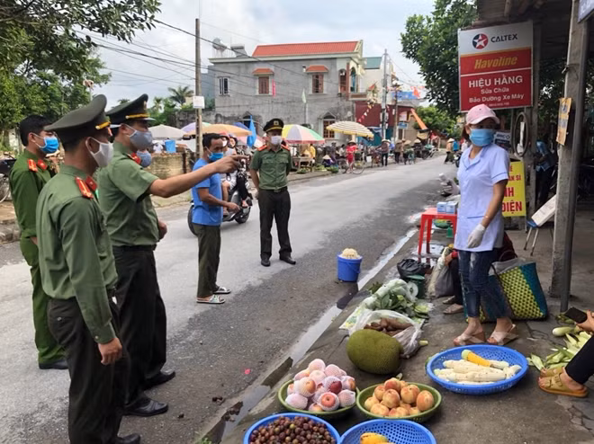 Cán bộ Công an vận động người dân chấp hành quy định chống dịch.