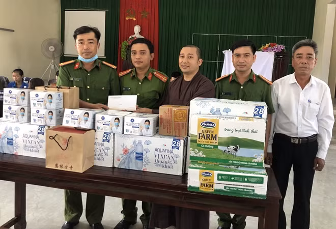 Đại đức Thích Huệ Trọng và đại diện cơ quan chức năng tặng quà động viên Tổ cấp CCCD tại xã Quảng Lợi.