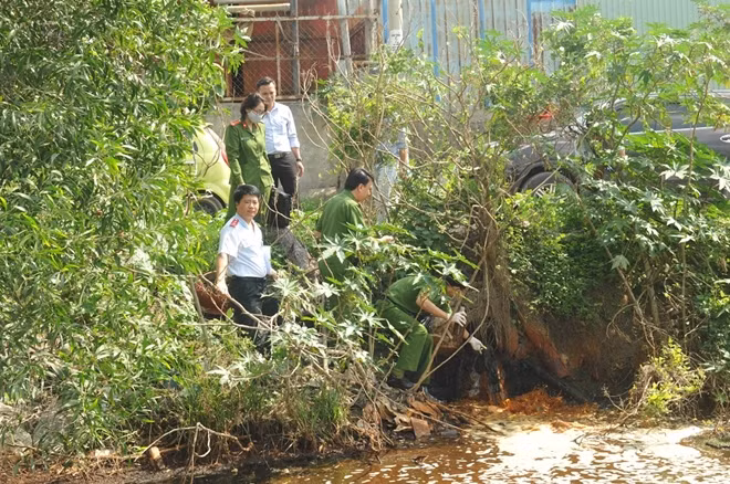Cán bộ Phòng 6 lấy mẫu nước thải để giám định.