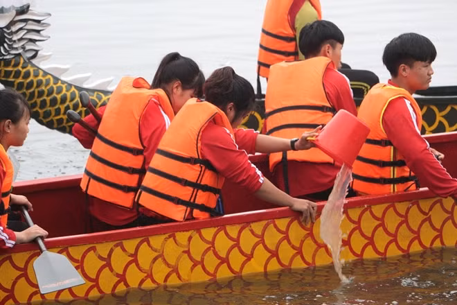 Trước khi đua các tay bơi thường phải múc bớt nước trong lòng thuyền để giảm trọng lượng.