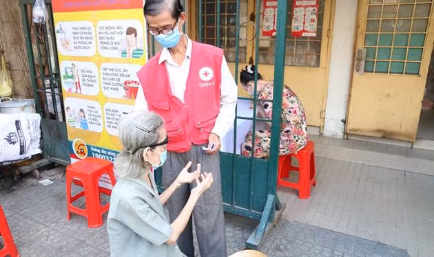 Người dân được kiểm tra thân nhiệt khi nhận quà tặng tại Trung tâm Hội chữ Thập đỏ (Q.6)