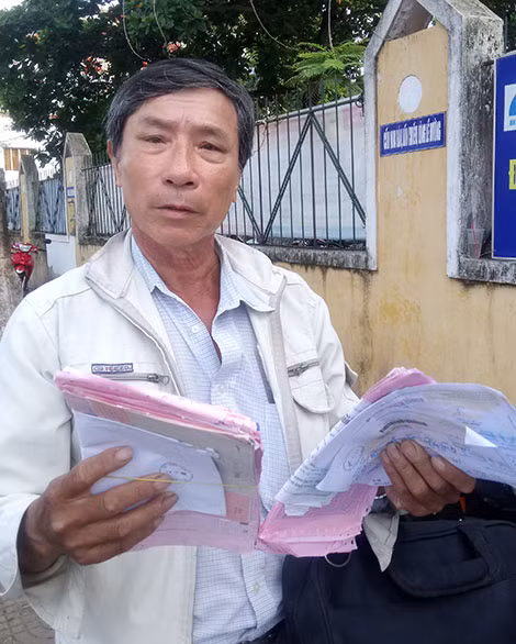 Ông Liêm với chồng hồ sơ đi khiếu nại 20 năm qua.