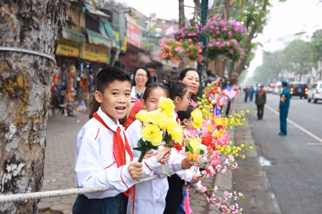 Các em học sinh vẫy hoa chào đón Chủ tịch Triều Tiên Kim Jong - un.
