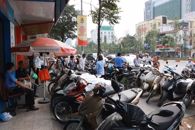 Một số lượng lớn xe máy của người dân xếp trước cửa là cảnh thường thấy tại các đại lý của những nhà mạng di động trong ngày 23-4 ngày cuối cùng trước khi Nghị định 49/2017 có hiệu lực.