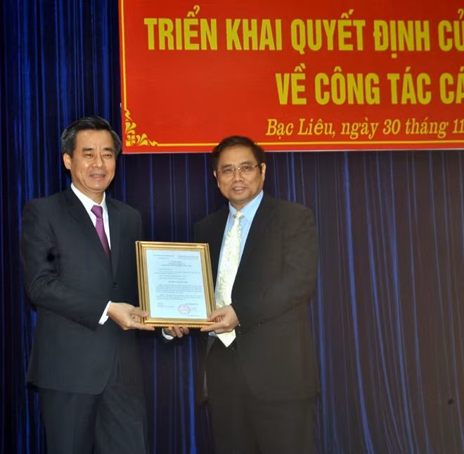 Đồng chí Phạm Minh Chính, trao Quyết định cho đồng chí Nguyễn Quang Dương (bên trái).