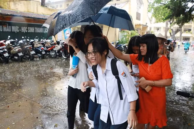 Các sĩ tử tuổi Rồng rời phòng thi dưới trời mưa tầm tã.