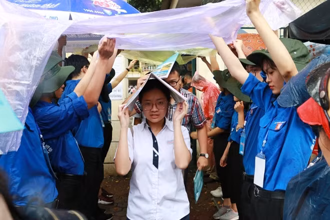 Bên ngoài cổng trường, các sinh viên tình nguyện cũng tự tạo một lối đi "tránh mưa" cho các em.