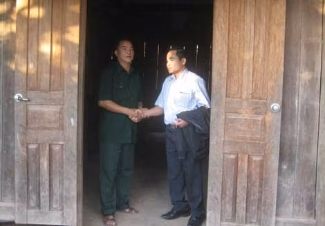 Thượng tá Đoàn Quang Sung (bên phải) tranh thủ gặp một người có uy tín trong cộng đồng người dân tộc thiểu số.