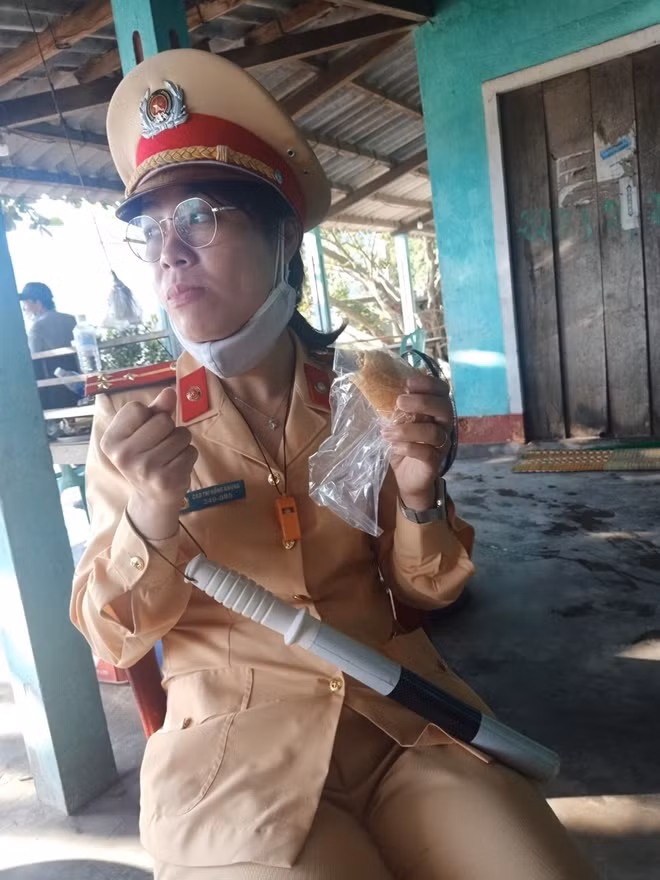 Thượng úy Nhung lót dạ bằng ổ bánh mì trước khi trở lại chốt kiểm soát y tế làm nhiệm vụ phòng chống dịch bệnh.