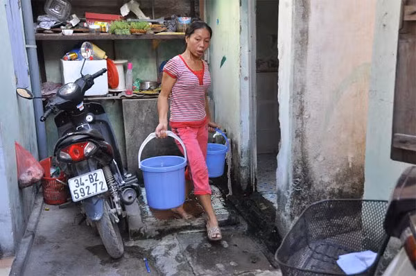 Những ngày mất nước sạch, người dân phải thường xuyên sách xô đến những gia đình cho giếng khoan để xin nước về dùng - Ảnh: Thanh Xuân.