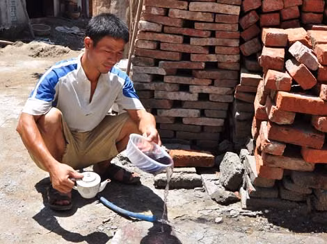 Anh Bình làm luôn thí nghiệm cho phóng viên chứng kiến độ ô nhiễm của nước giếng khoan nhà mình.