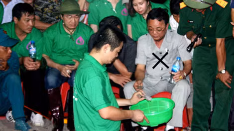 “Cậu Thuỷ” (áo trắng, dấu X) trong một màn lừa đảo quy tập hài cốt liệt sĩ. “Cậu Thuỷ” (áo trắng, dấu X) trong một màn lừa đảo quy tập hài cốt liệt sĩ.