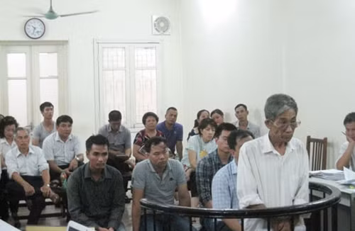 Ông Tùng (áo trắng, hàng đầu) tại phiên xử sơ thẩm lần 1.