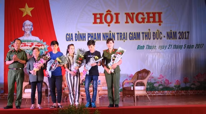 Đại tá Trần Hữu Thông tặng hoa chúc mừng một gia đình phạm nhân cải tạo tốt.