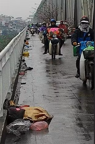 Trên cầu Chương Dương, nhiều túi ni lông đựng cá, ốc… bị vứt bừa bãi, treo trên thành cầu sau khi người dân phóng sinh.