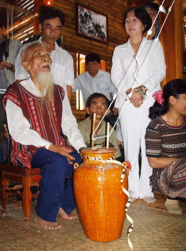 Vợ chồng già làng Tơ Tơ với bình rượu ịch cúng Nhang (thần linh) sau quá trình làm men ủ rượu. Ảnh: Bảo tàng Đồng Nai.