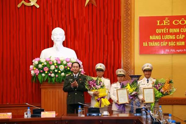 Bộ trưởng Trần Đại Quang tặng hoa chúc mừng các đồng chí được thăng cấp bậc hàm cấp Tướng CAND. Ảnh Việt Hưng.