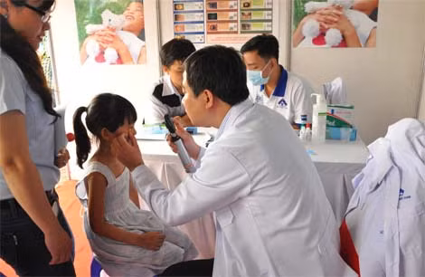 Bác sĩ Bệnh viện Mắt thành phố khám mắt cho trẻ tại ngày hội.