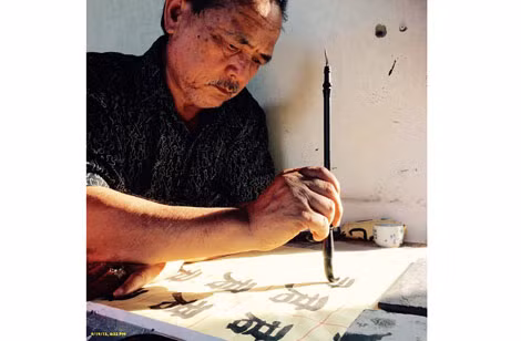 Nhà thơ Y Phương đang “luyện chữ”.