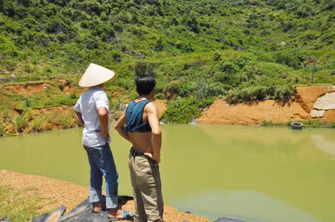 Hố chứa rác thải trước đây bị bục bạt khiến nước đen rò rỉ chảy ra mương máng của người dân.