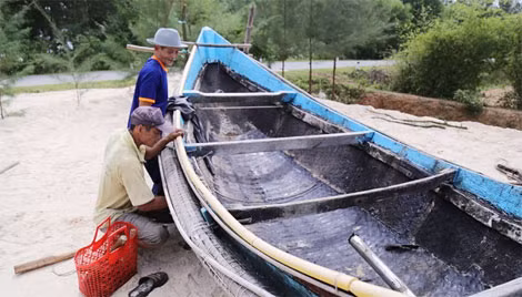 Ông Sơn (huyện Gio Linh, Quảng Trị) cùng con trai đưa chiếc thuyền nan 90CV lên bờ để tu sửa, chờ mùa biển mới. “Hy vọng cuối tháng 8 âm lịch, biển lại có cá để ngư dân chúng tôi ra khơi”.