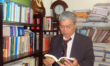 Nhà thơ Phạm Quốc Ca bên tủ sách của mình.