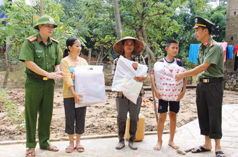 Đại diện Báo CAND và Công an huyện Bố Trạch, Quảng Bình trao quà giúp đỡ người dân vũng lũ ở Trằm Mé, Sơn Trạch, Bố Trạch, Quảng Bình.