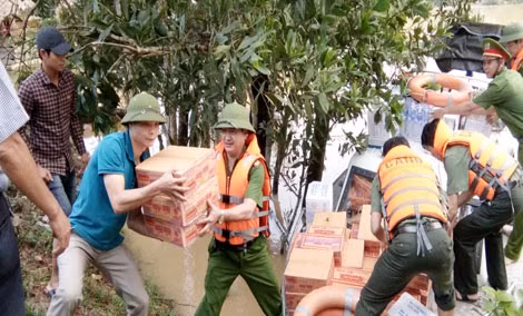 Cán bộ Báo Công an nhân dân và Công an huyện Hương Khê vận chuyển lương thực đến các hộ gia đình bị cô lập bởi mưa lũ.