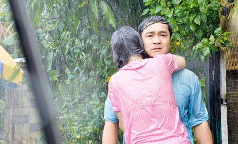 Lý Hùng và Kim Chi diễn xuất mùi mẫn dưới mưa trong phim “Cuộc chiến quý ông”.