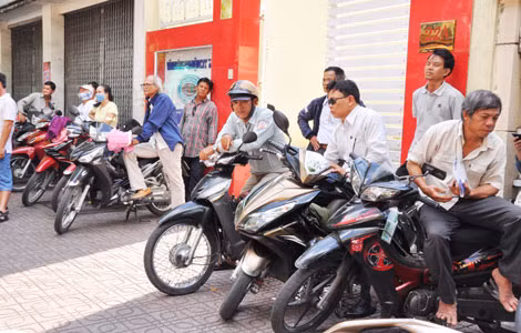 Mệt mỏi, bơ phờ ngồi chờ con bên ngoài điểm thi.