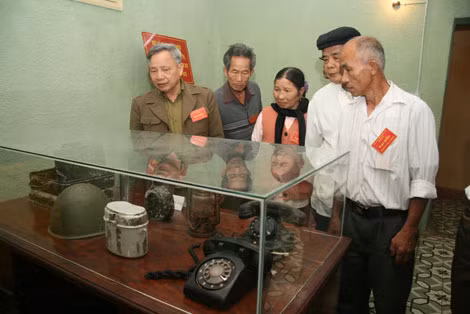 Cựu binh Ngô Mạnh Giang (bìa trái) và đồng đội xem các hiện vật lịch sử trưng bày trong hầm ngầm Nhà D67.