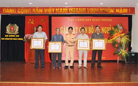 Thiếu tướng Trần Sơn Hà, Cục trưởng Cục Cảnh sát Giao thông trao Huy chương Chiến sĩ vẻ vang cho các đồng chí nguyên lãnh đạo Cục CSGT. Ảnh Việt Hưng.