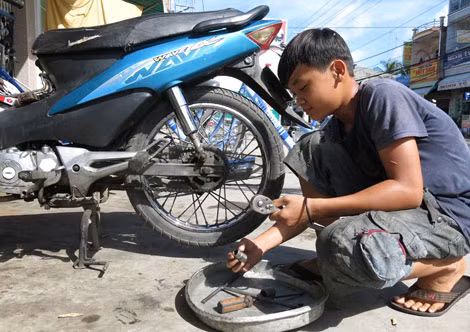 Luân chú tâm học nghề sửa xe môtô. Luân chú tâm học nghề sửa xe môtô.