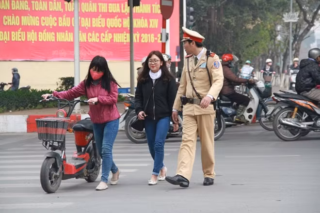 Đi xe đạp điện, xe máy điện không đội mũ bảo hiểm.