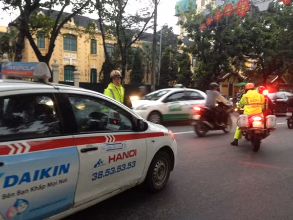 Khi chiếc xe cẩu chuyên dụng của CSGT chặn trước đầu xe taxi, lái xe taxi cho xe lùi, tiếp tục bỏ chạy.