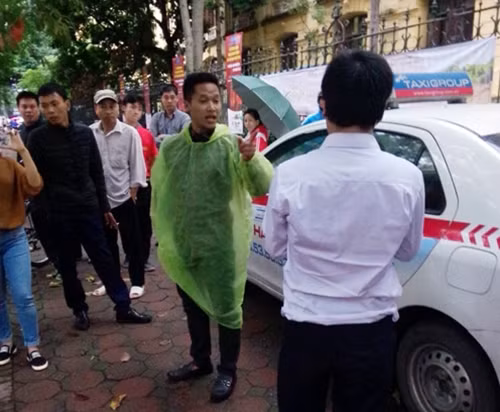 Người dân bức xúc phản ứng với lái xe taxi (áo trắng) sau khi anh này ra khỏi xe.