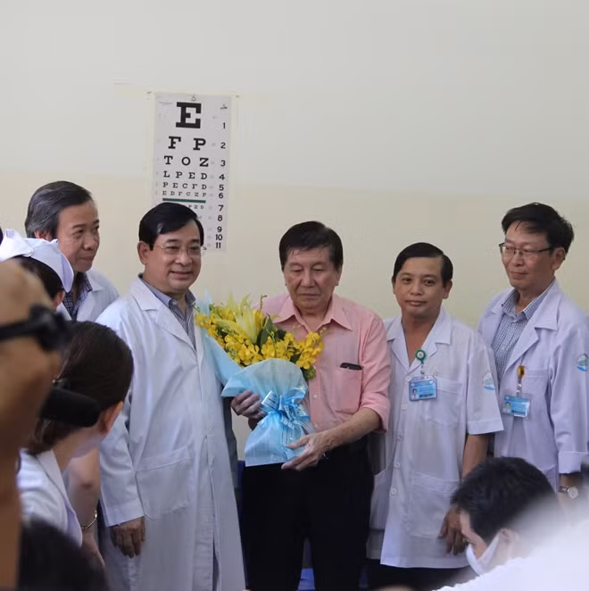 Ông T.K.H chụp hình lưu niệm với các thầy thuốc của Việt Nam và xúc động nhận bó hoa tươi thắm từ PGS.TS Lương Ngọc Khuê trao tặng