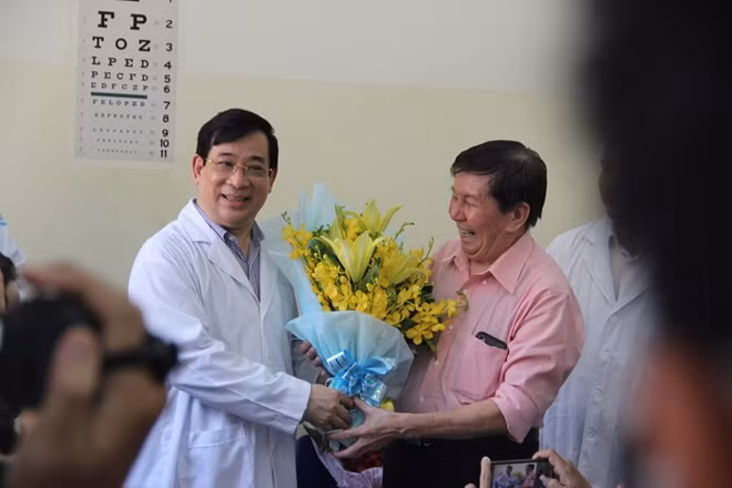 Bệnh nhân T.K.H. đã khoẻ mạnh, được xuất viện vào chiều 21/2, bắt tay PGS.TS Lương Ngọc Khuê mà không cần đeo khẩu trang.