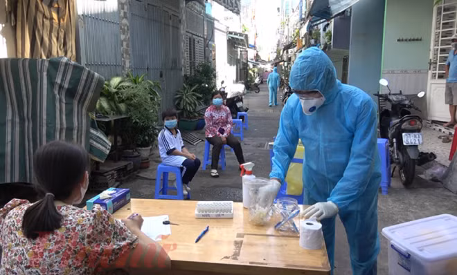 Lấy mẫu xét nghiệm người dân ktại một con hẻm quận 6 TP Hồ Chí Minh liên quan bệnh nhân COVID-19 mới. (Ảnh: Báo Phụ nữ)