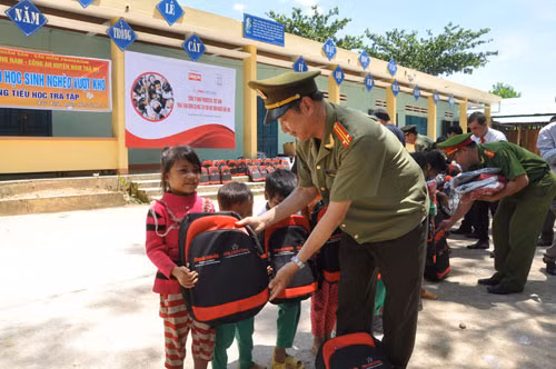Đại diện Báo CAND tặng quà các em học sinh rẻo cao Trà Tập .