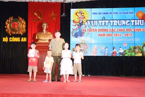 Các cháu học sinh giỏi, có hoàn cảnh khó khăn vươn lên trong học tập năm học 2014-2015 và các cháu có hoàn cảnh đặc biệt khó khăn nhận quà từ Lãnh đạo Tổng cục và Ban tổ chức.