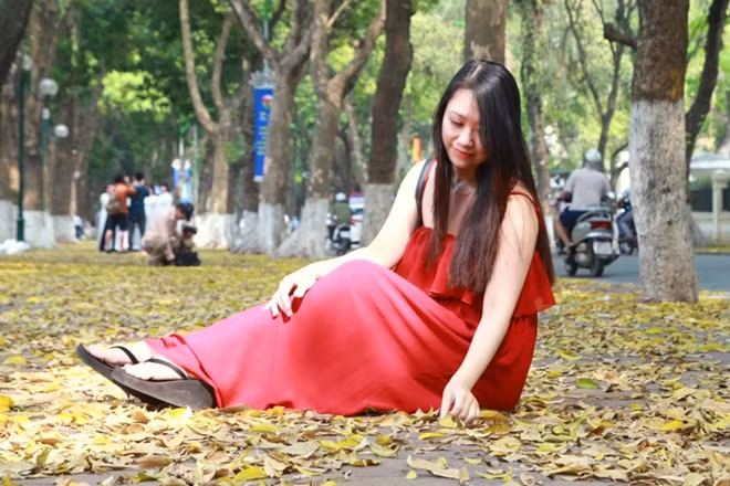 Thiếu nữ tạo dáng trên thảm lá vàng.