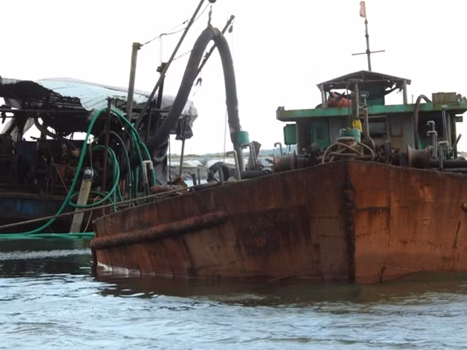Một tàu đang sử dụng ống hút cát từ dưới biển lên, sau đó vận chuyển vào bờ đem bán kiếm lời