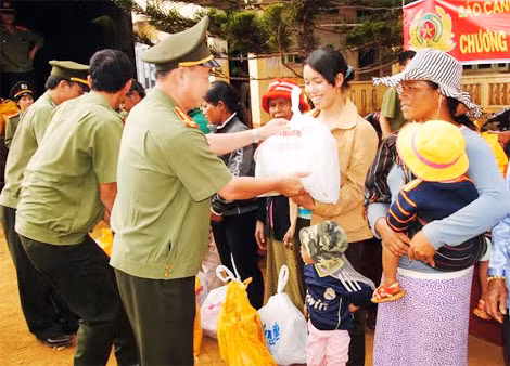 Đại tá Trần Kim Thẩm, Phó tổng biên tập Báo CAND tặng quà cho bà con nghèo tại xã Đắk Som, huyện Đắk Glong.