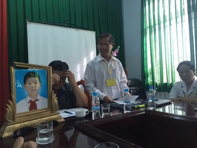 Người nhà mang di ảnh cháu bé đến buổi làm việc