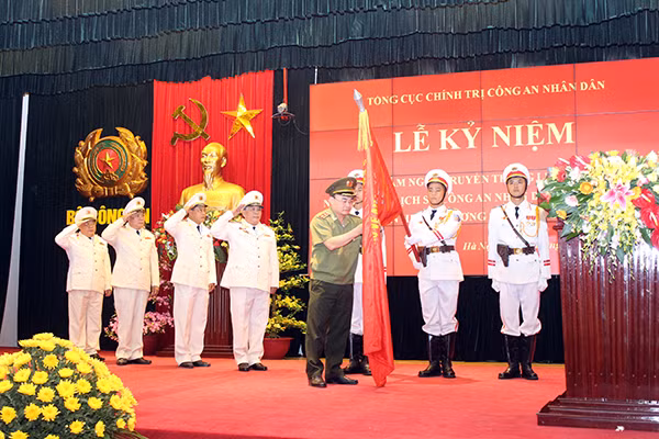 Thứ trưởng Bùi Quang Bền gắn Huân chương Bảo vệ Tổ quốc hạng Ba lên Cờ truyền thống của Viện Lịch sử Công an.