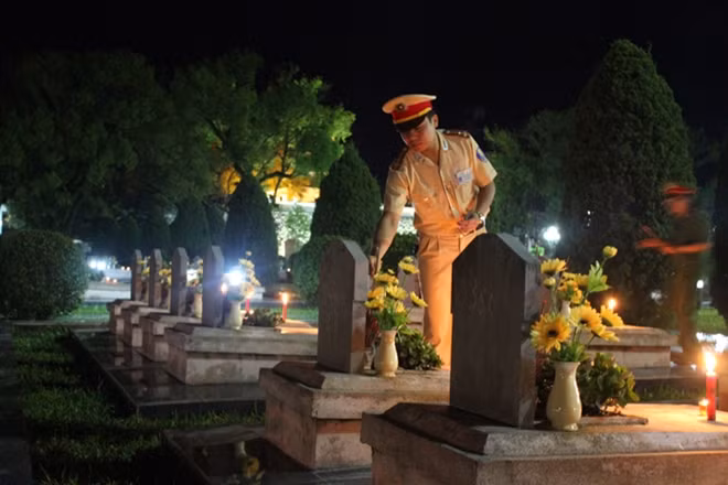 Thượng úy Phạm Trường Sơn - Cán bộ Phòng Cảnh sát giao thông Công an tỉnh Điện Biên thắp hương phần mộ các anh hùng liệt sĩ tại Nghĩa trang quốc gia A1 trong đêm thắp nến tri ân nhân ngày Thương binh liệt sĩ 27/7 do Công an tỉnh Điện Biên tổ chức.