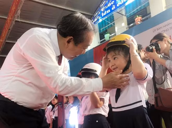 Phó Thủ tướng Thường trực Trương Hoà Bình trao mũ bảo hiểm cho các em học sinh trường tiểu học Phù Đổng.