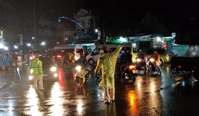 CSGT đội mưa hướng dẫn giao thông ở Chợ Viềng tối 22-2 (Ảnh: Mạnh Thắng)